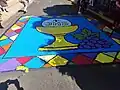 Corpus Christi carpet with the use of the acronym in São Manuel, São Paulo, Brazil.