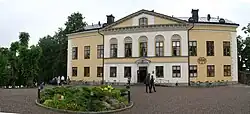 Large, two-story tan-and-white house