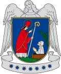 A coat of arms depicting a bishop in brown robes with a brown mitre on his head surrounded by a golden halo looking at another man