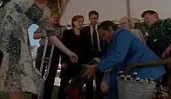 A man is attaches an artificial leg while people watch.