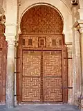 One of the seventeen carved-wood doors of the prayer hall