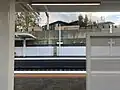 Platform 3 station signage and shelter viewed from Platform 1, May 2023