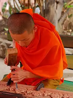 Image 19Monk woodworking temple details (from Culture of Laos)