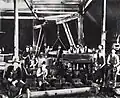 Workers in the 1890s, holding up the tools of trade used in manufacturing locomotives and agricultural and mining equipment