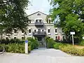 1906/07, Friedrich von Thiersch built a youthfully designed hipped roof house in the Mandlstraße 1, in front of it is a 1907 designed fountain from Mathias Gasteiger with two youthful figures.
