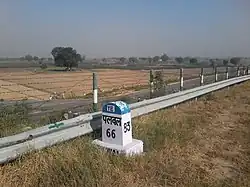 The milestone is made in front of the way of turning entrance into village road.